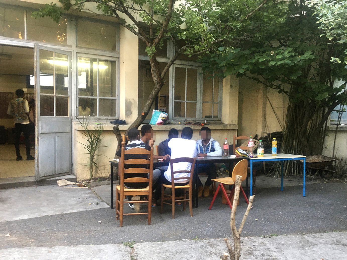 Jeunes accueillis par La Casa réunis autour d'une table dans une cour