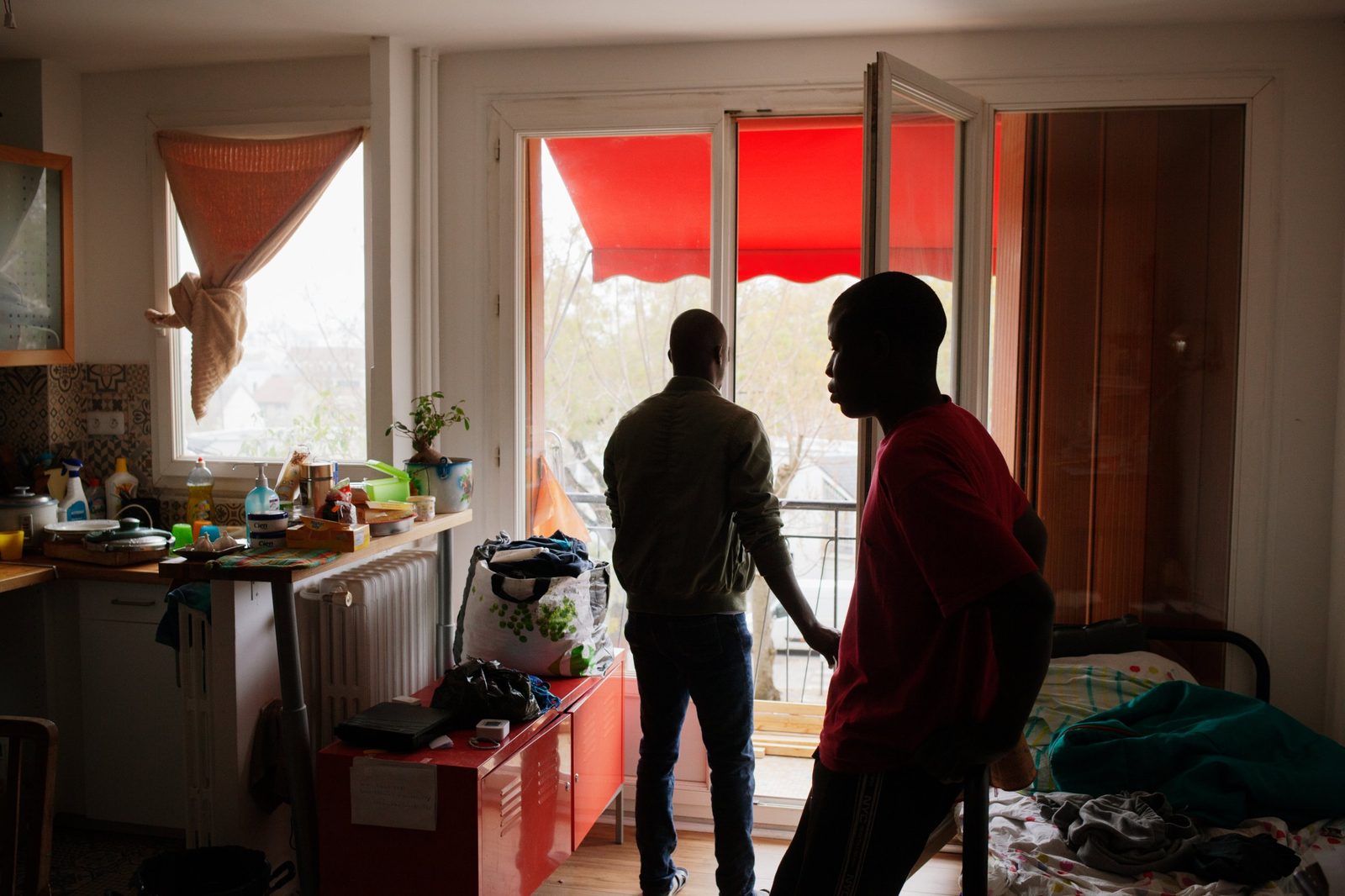Deux jeunes dans l'un des logements de La Casa, devant une fenêtre ouverte